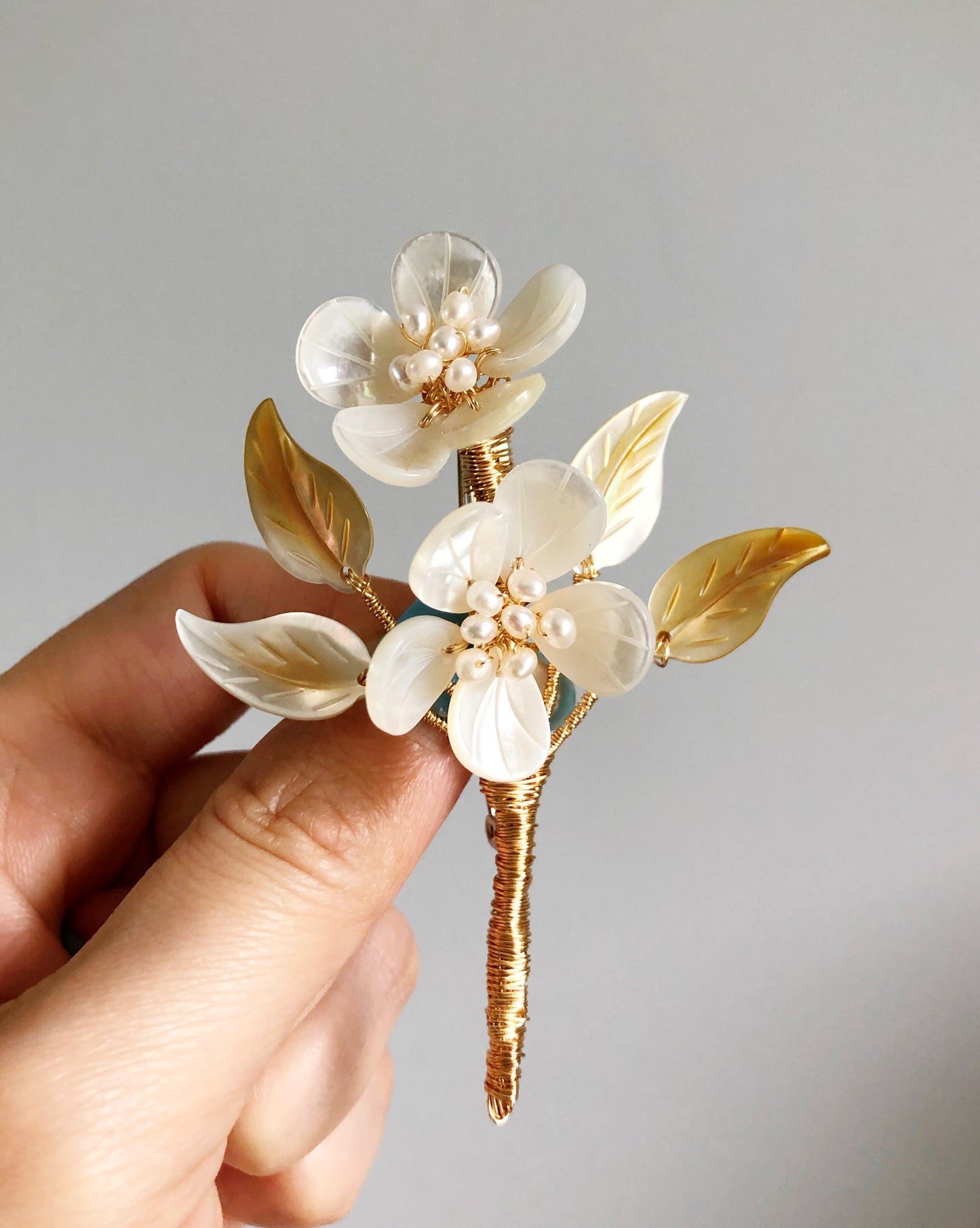 A mother’s embrace shell and freshwater pearl brooch (yellow and white)