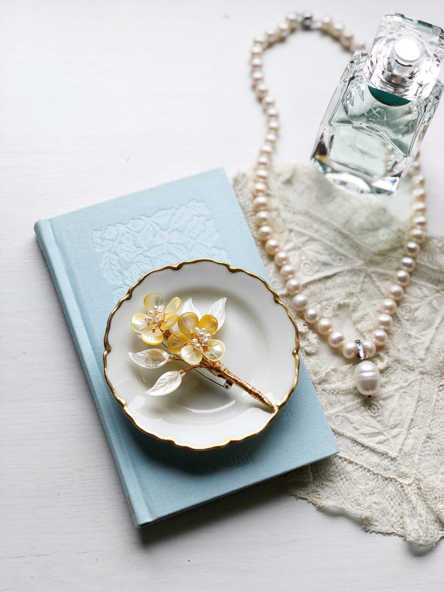 A mother’s embrace shell and freshwater pearl brooch (yellow and white)
